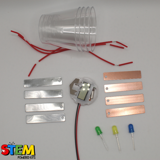 Unassembled components of the Fruit Battery STEM Kit, including copper and zinc plates, wires, LED lights, and cups for conducting fun and educational STEM experiments.