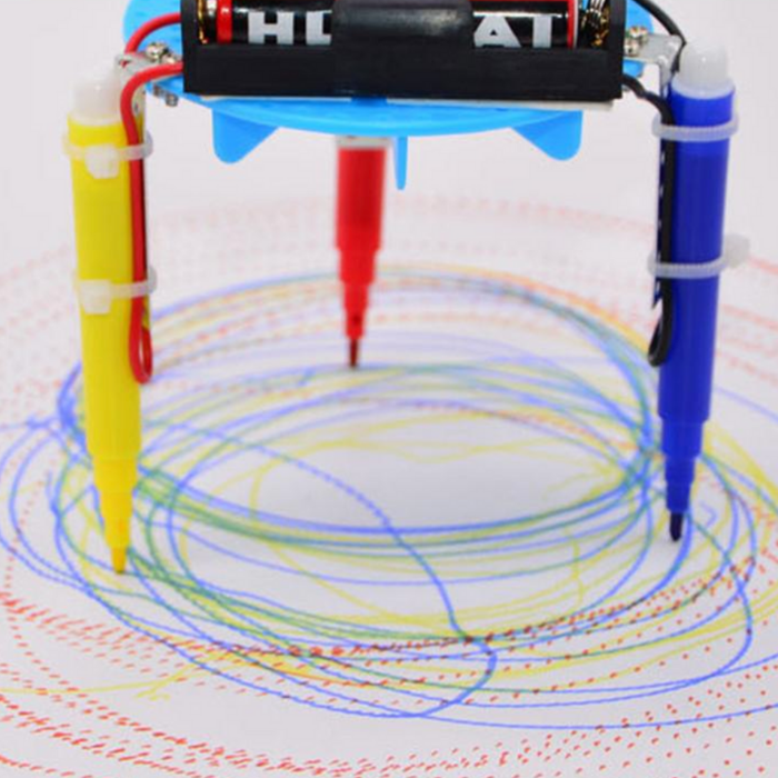 Side view of the fully assembled plastic Graffiti Robot, featuring a colorful design with googly eyes, a motor, and markers for automated art creation.